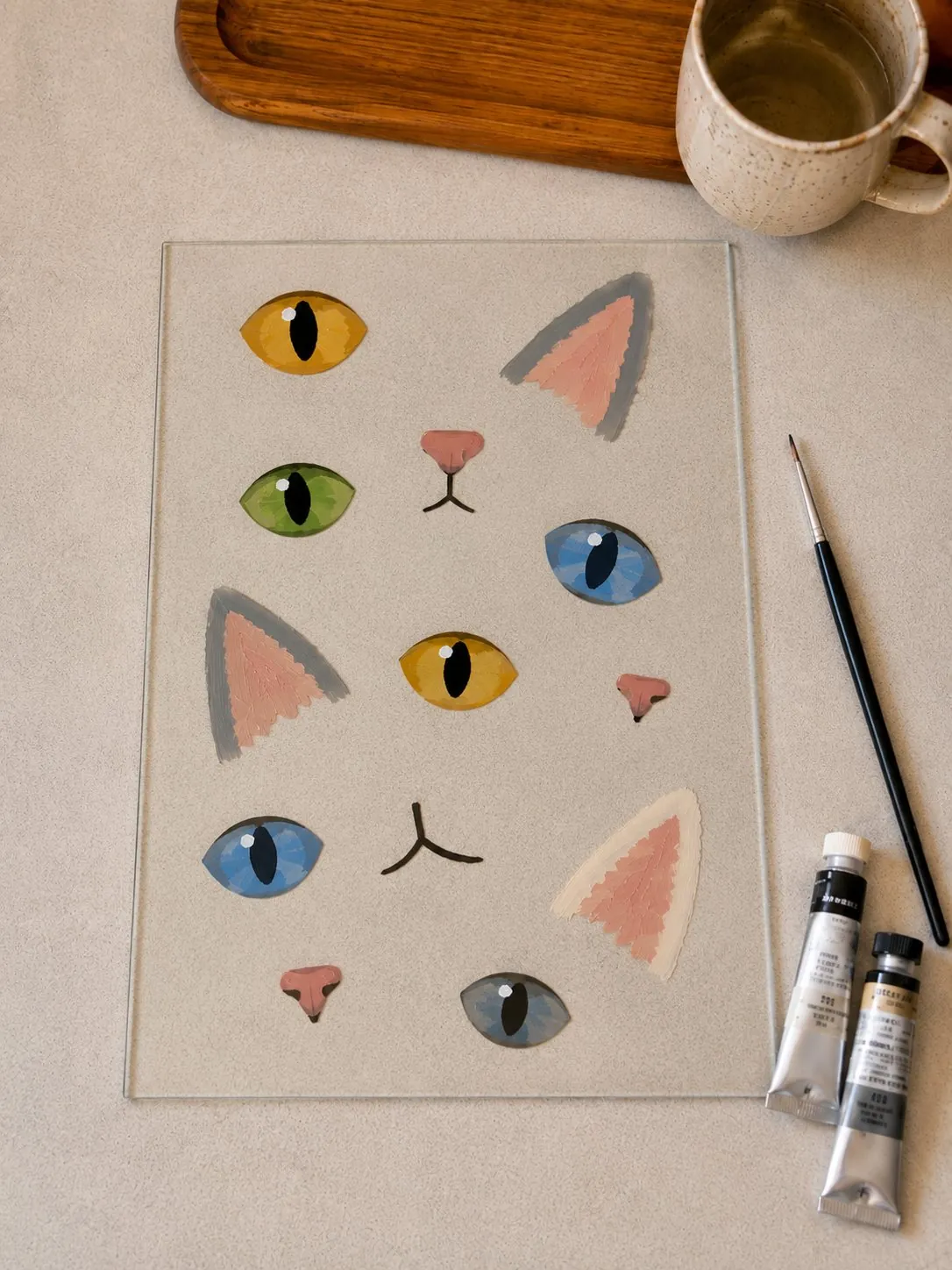 A practice sheet of cat eyes, ears and noses painted on the glass